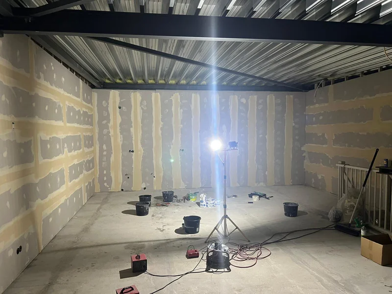 Systeemwanden in afwerkfase — gipsplaten geplamuurd en klaar voor stucwerk, kantoorrenovatie Amsterdam